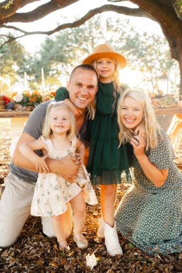 Megan Branham, pharmacist with Hawthorne Pharmacy, and her husband Corey hug their daughters, CoraLee and Marley