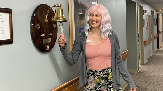 Danielle rings the bell celebrating the end of treatment