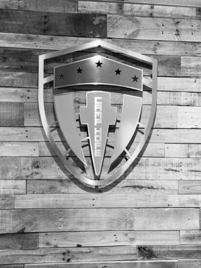 The Camp Hope Shield logo representing each branch of the military and a cross denoting faith-based service.