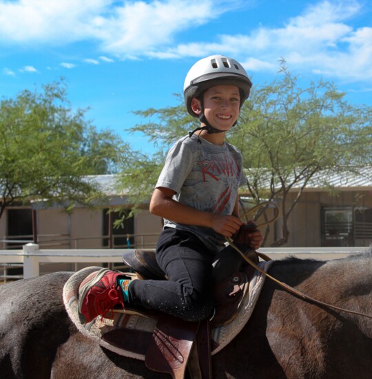 All smiles from Ezra as he finishes up his turn through the horseback relay!