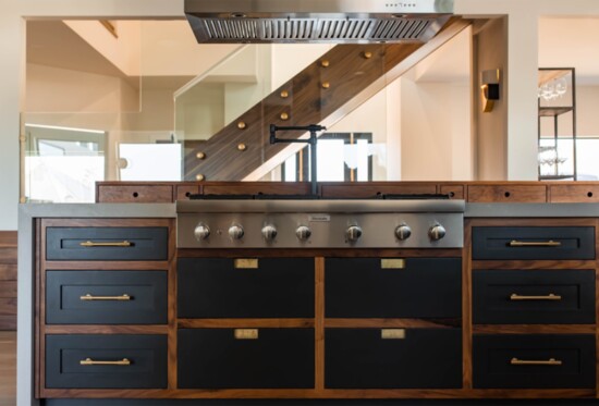 Floating glass elements and appliance coverings make this kitchen luxe and airy