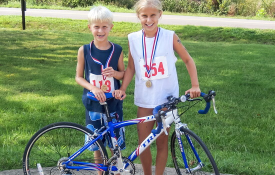 Kalie Carter Brown proudly shows off the tri bike that she won in raffle during the Kids Triathlon.