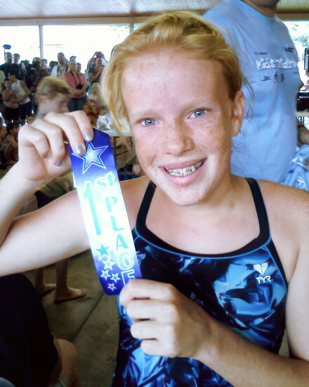 Erica Hudson proudly shows off her 1st place finisher ribbon.