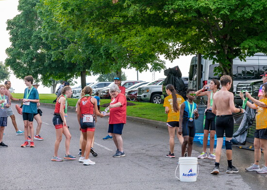 Young athletes receive their medals and cool down after finishing their triathlon.