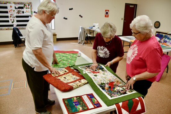 Oklahoma Home and Community Education Sunshine group members Donna DeMun, Vickie Gray and Louise Moody look over Christmas projects. 