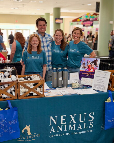 Amanda Stump (far left, Nexus Animals development manager, pose alongside volunteers at an event.