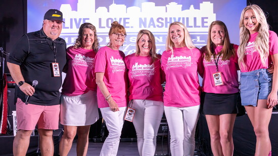 Emcee Andy Gilley poses with Taylor Reed and her Live Love Nashville team during the Hometown Jam concert for kids.