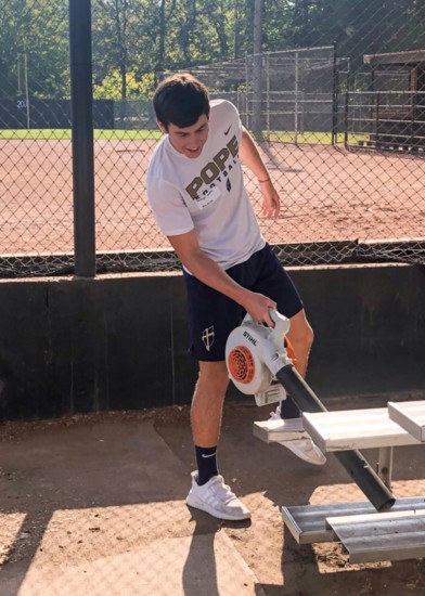 A Pope John Paul II student helping clean up the ball park bleachers at Drakes Creek Park.