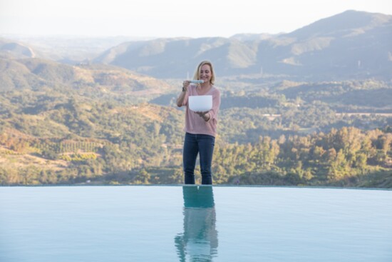 Margo Jolly, Co-Founder of Sheros Retreat at the edge of the infinity pool with crystal quartz singing bowls.