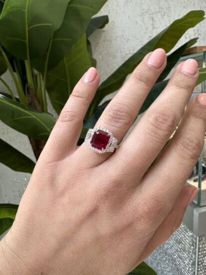 For Her: An emerald cut ruby with diamond trapezoid side stones and diamond halo all around