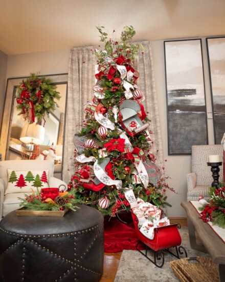 Colorful sleds serve as focal points on + under this whimsical Christmas tree.