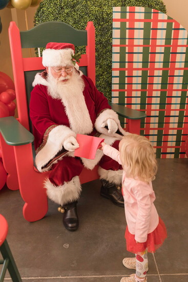 Santa Claus greets families at the Holiday Modern Market, spreading cheer and holiday spirit to all.