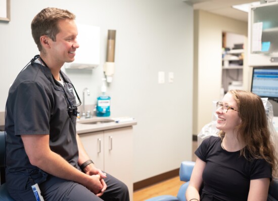 TOP: Dr. Dan Tibbetts works with a patient