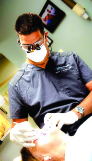 TOP: Dr. Robert Spennato works with a patient