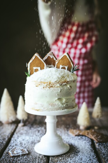 Naked Cake topped with a gingerbread house and coconut flakes to resemble snow