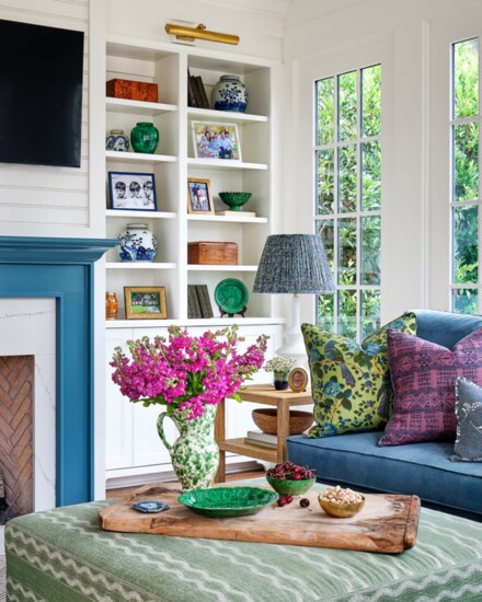 An oversized ottoman upholstered in Peter Dunham’s Zanzibar fabric anchors the den. Sherwin Williams’ Mediterranean paint adds a pop of blue on the mantle.