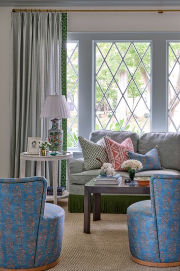 The original Tudor window bathes the living room in natural light. A pair of Coley Home chairs are upholstered in Bastideaux's Arles fabric. 