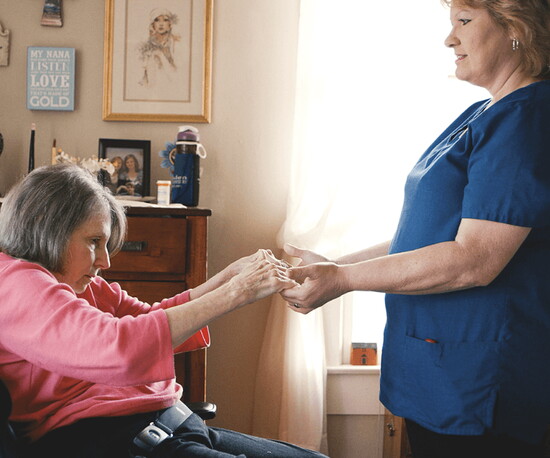 Home Helpers' supervisor of caregiving assists a client stand up