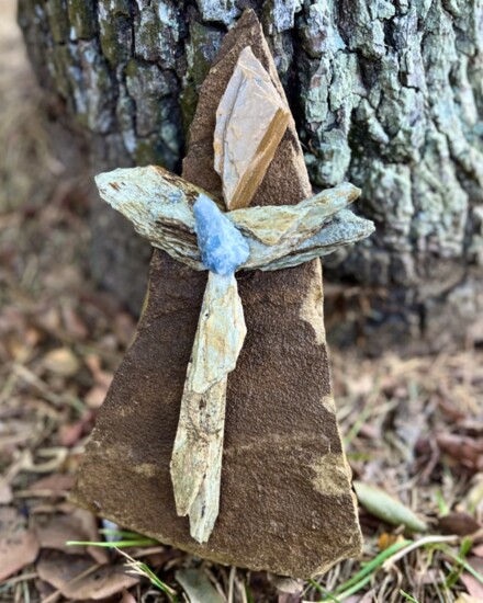 A freestanding stone sculpture with a turquoise "burst of faith"