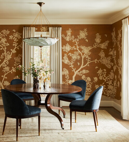 The dining room pairs a striking two-color Gracie wallpaper with the homeowners' existing table, blue velvet Hickory Chair seating and a silk Fortuny pendant