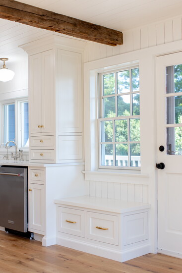 This custom kitchen built-in combines beauty and utility, perfect for additional storage or a cozy spot to take off your shoes.