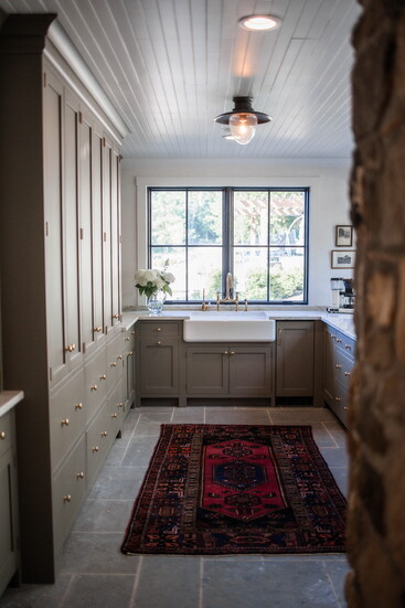 A vintage rug adds warmth and personality to this streamlined scullery.