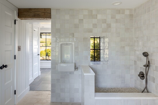 Soft neutrals, handmade tile, and natural light bring calm to this utility space. Plus, a built-in water fountain adds a fun and functional surprise.
