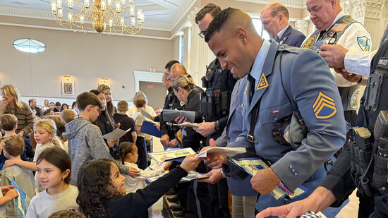 Children greet local police officers with smiles and excitement.