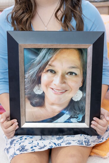 Lucia, age 10, holds a photo of her mother, Chris Xeil Lyons, who passed away in December. 
