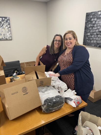 Nicole Bienko and Andrea Kryscnski pack boxes for service members