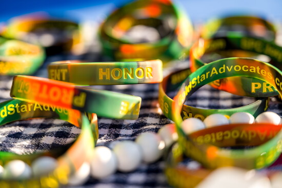 Colorful wristbands bearing messages of honor and advocacy displayed for attendees.