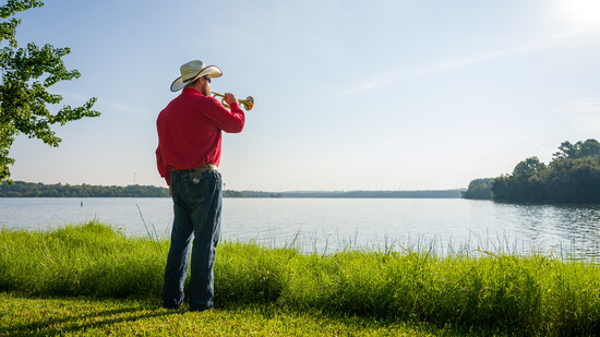 Bugler plays “Taps” beside Lewis Creek Reservoir during the SPC Joey Lenz dedication.