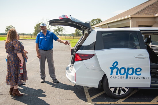 Driver showing off one of Hope Cancer's fleet vans