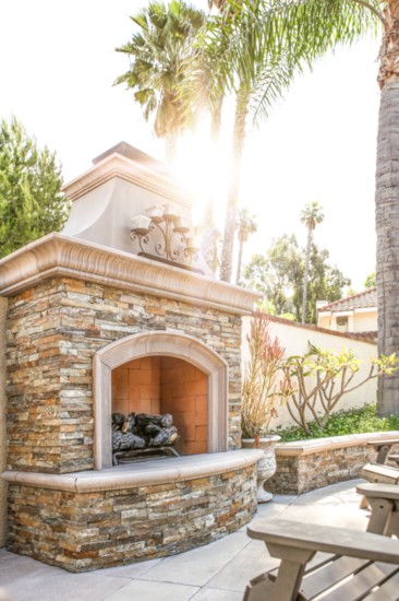 Everyone has a place by the hearth at this durable outdoor fireplace made of hand-laid stone and concrete.