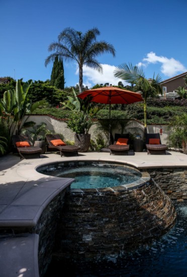 The waterfall effect: the spa empties into the pool with light water splash over rough stone.