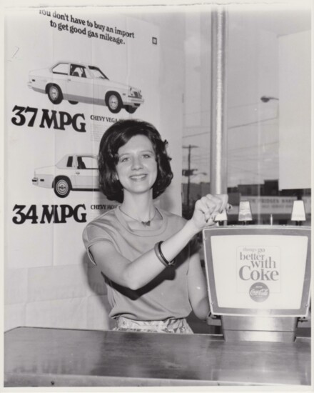 Wanda serves Coca-Cola while a college student at her dad’s new dealership.