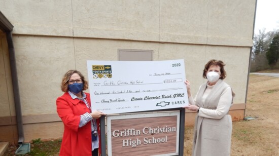 Wanda (right) presents a check to Griffin Christian High School to support their sports programs.