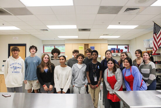 Students participating in The Giving Table team up to cook for two families at the club's inaugural meeting