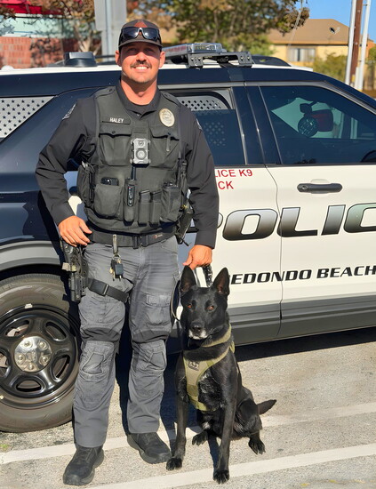Officer Haley and Max pose beside their patrol vehicle, which proudly bears Max's name.