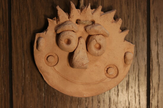 Cam’s very first clay self-portrait that hangs above his pottery wheel today.