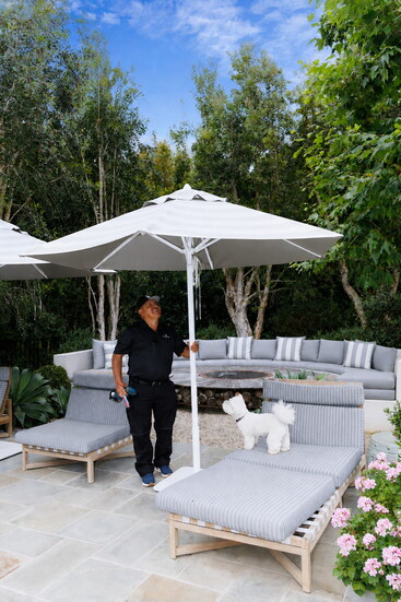 Facilities manager Juan Padilla tending to a pool umbrella