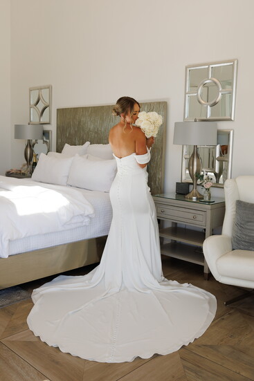 Kaitlyn Sherfy attired in the off-the-shoulder bridal gown provided by Blushing Bride Bridal Boutique.