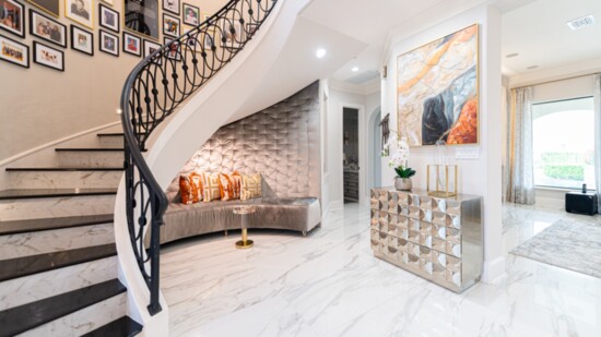 For this foyer , Houston interior designer Shundra Harris created a cozy nook with an upholstered wall under the stairs.