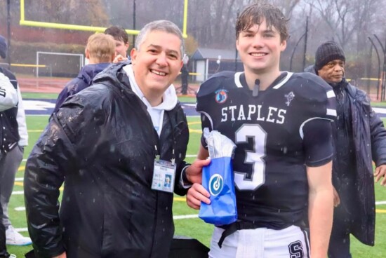 Estevao Divino of PrepZone presents the Restore Player of the Game award to Staples Quarterback Nick Weil.