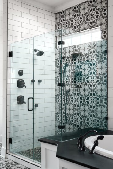 Contrasting tile and glass doors create a striking visual appeal in this bathroom.