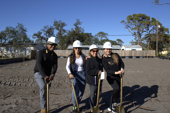 Family members John Truland, Genna Torres, Luz Torres, and Luisa Vargar smile as they look forward to their future Habitat home.