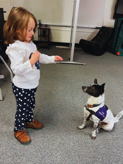 A Caring Canine therapy dog working with an elemantary school student