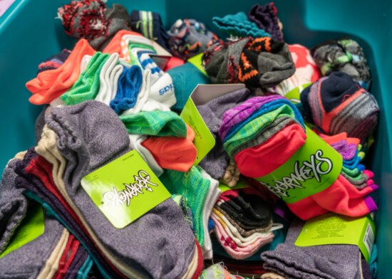A basket of colorful socks is ready to be distributed to students.