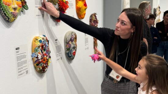 WomenGive Recipient Linley Campbell and her daughter Bella Camacho looking at the MASK they created for the MASKs exhibit at the Museum of Art in Fort Collins
