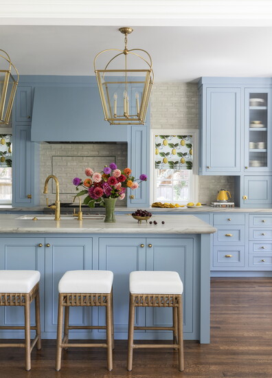 Light blue paint and lemon - pattern window blinds bring fresh color to this kitchen designed by Emily Spanos.
